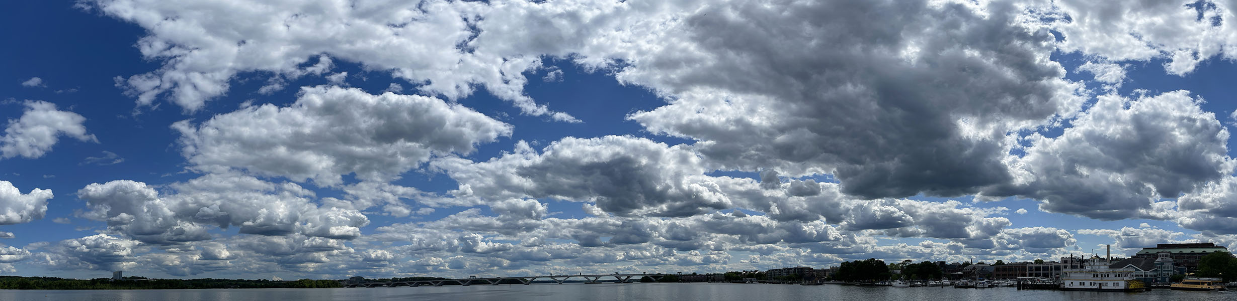 Color Panoramic Photo of River, Mostly Sky with Many Clouds.
